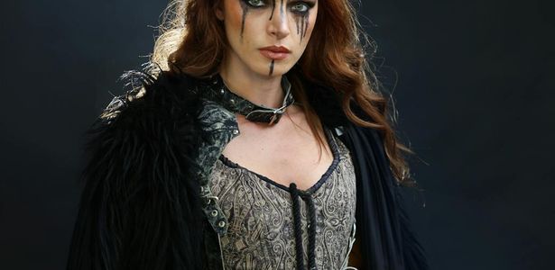 Person in a strong warrior yoga pose against a dark background.